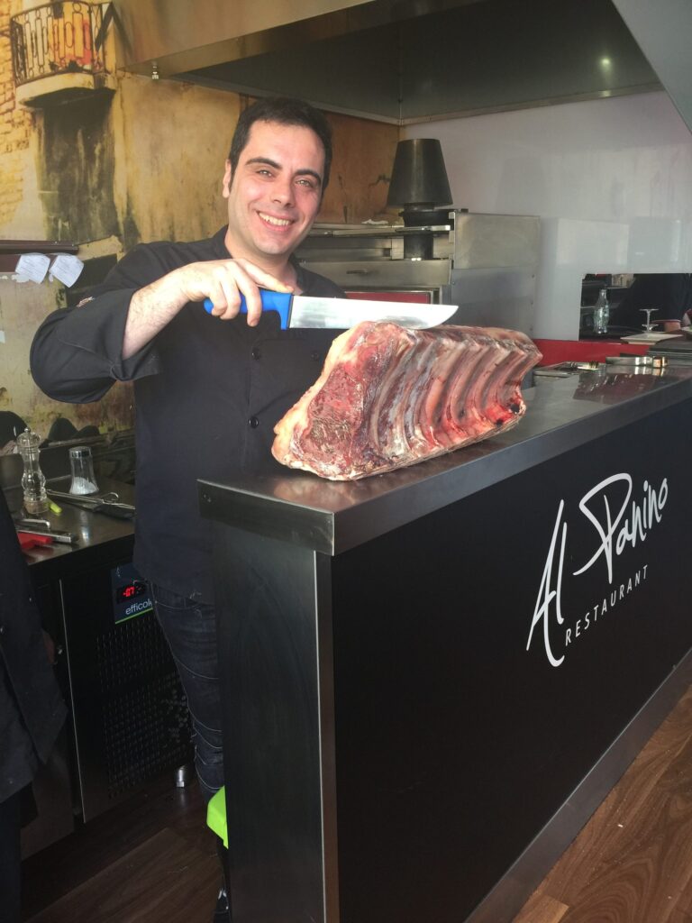 Javier Sierra tallant carn a la barra d'Al Panino