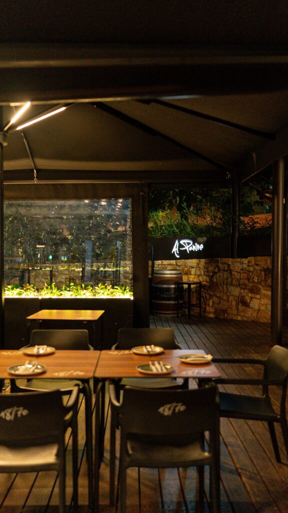 Terrace tables in the evening, beside the lit planter