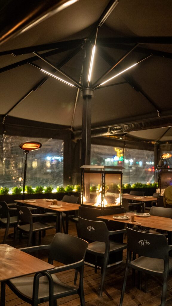 The terrace at night, with tables under the pergolas